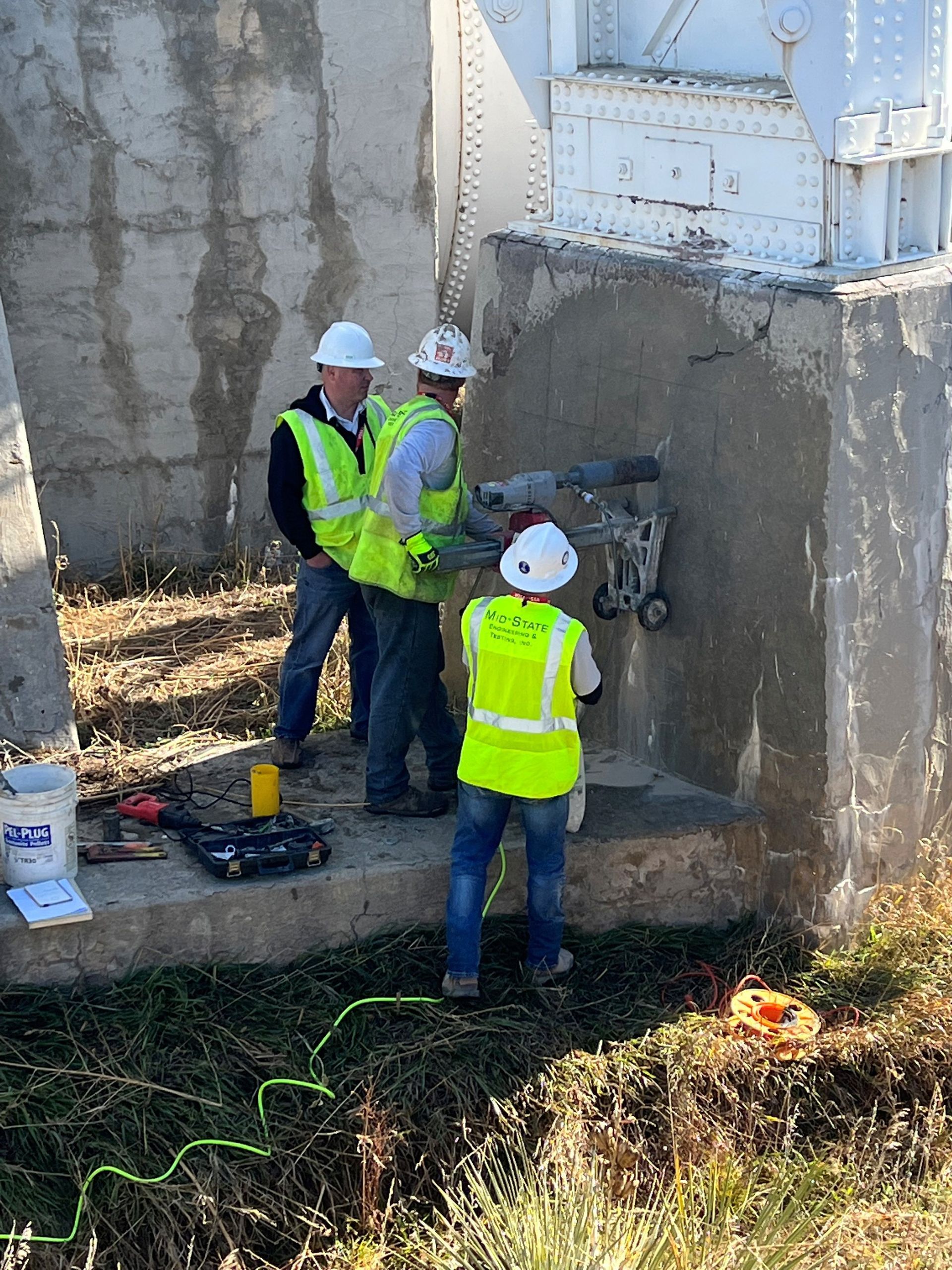 A group of construction workers are working on a concrete wall.