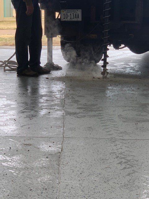 A man is standing next to a drilling truck