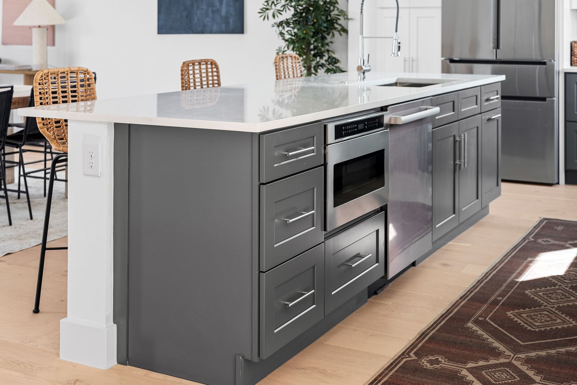 Gray kitchen island with built-in appliances and white countertop