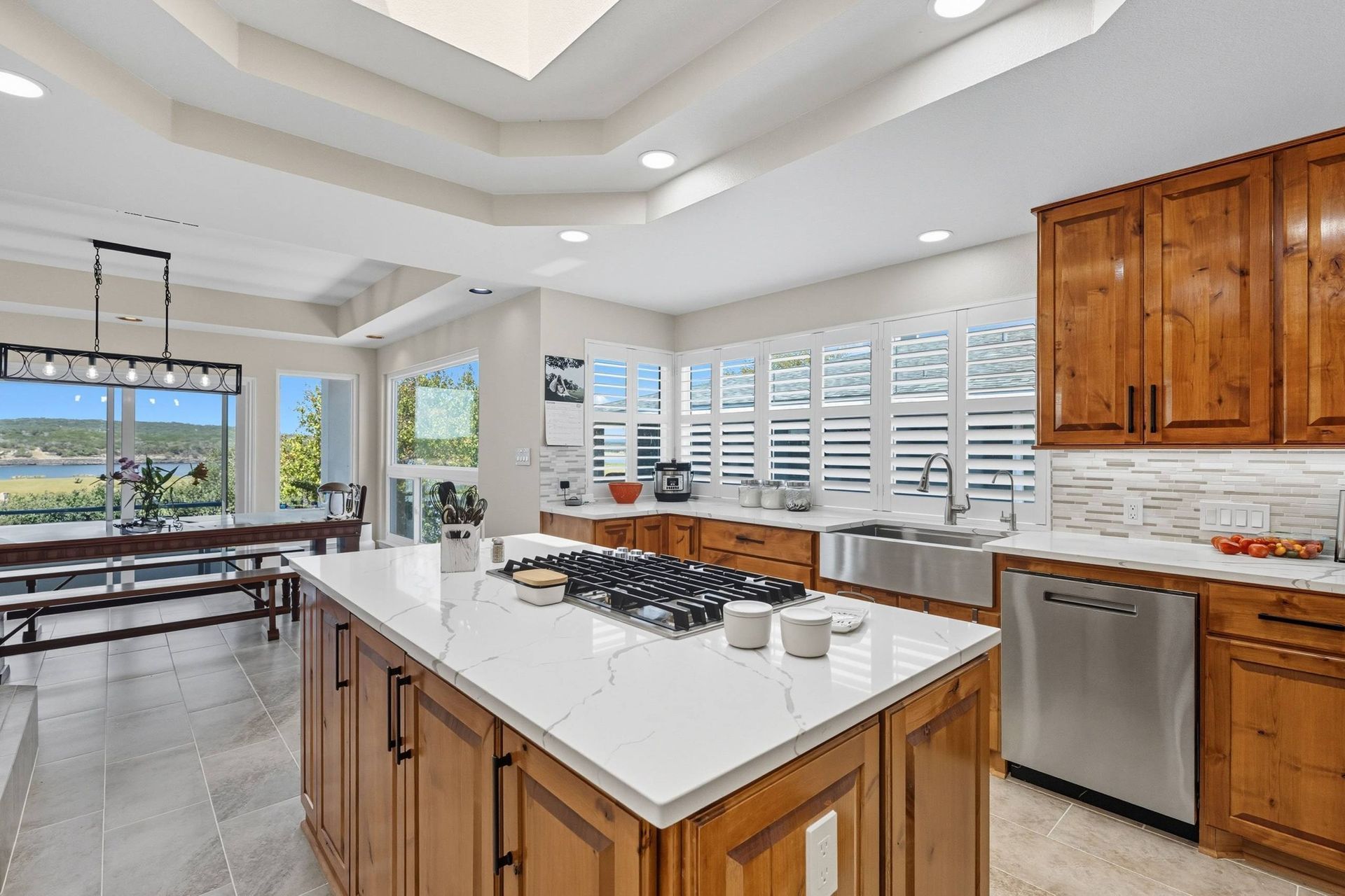 Spacious kitchen with island, wooden cabinets, stainless steel appliances, and a dining area with a lake view