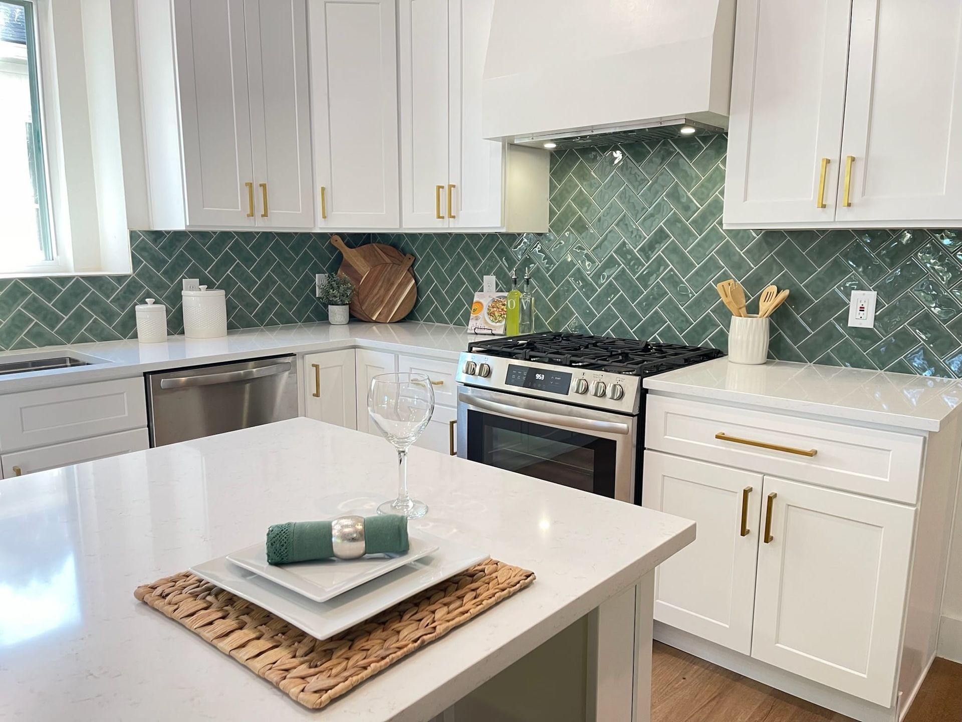 White kitchen with green backsplash, stainless steel appliances, and island with place setting.
