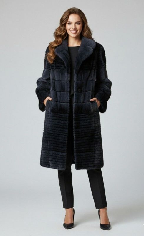 Woman in dark blue fur coat, standing with hands in pockets.