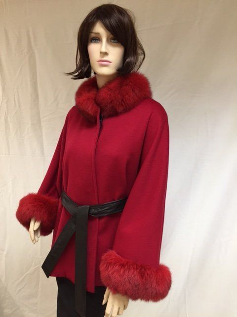 Mannequin wearing a red coat with a fur collar and cuffs, black belt.