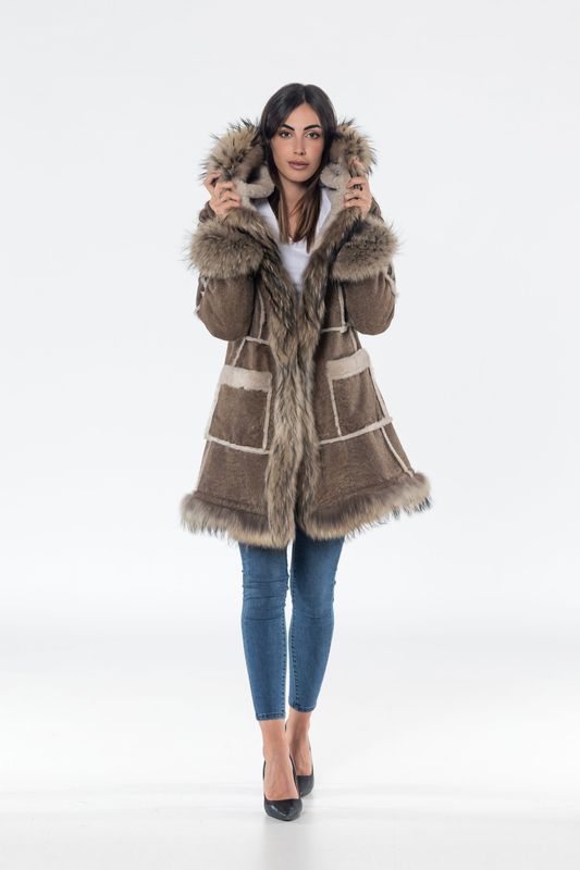 Woman in brown hooded coat with fur trim, jeans, and heels.