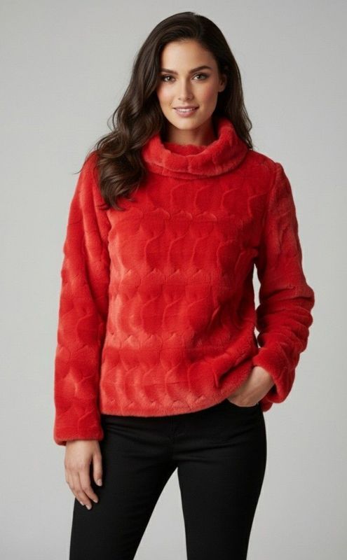 Woman in red faux-fur sweater, black pants, standing, smiling.