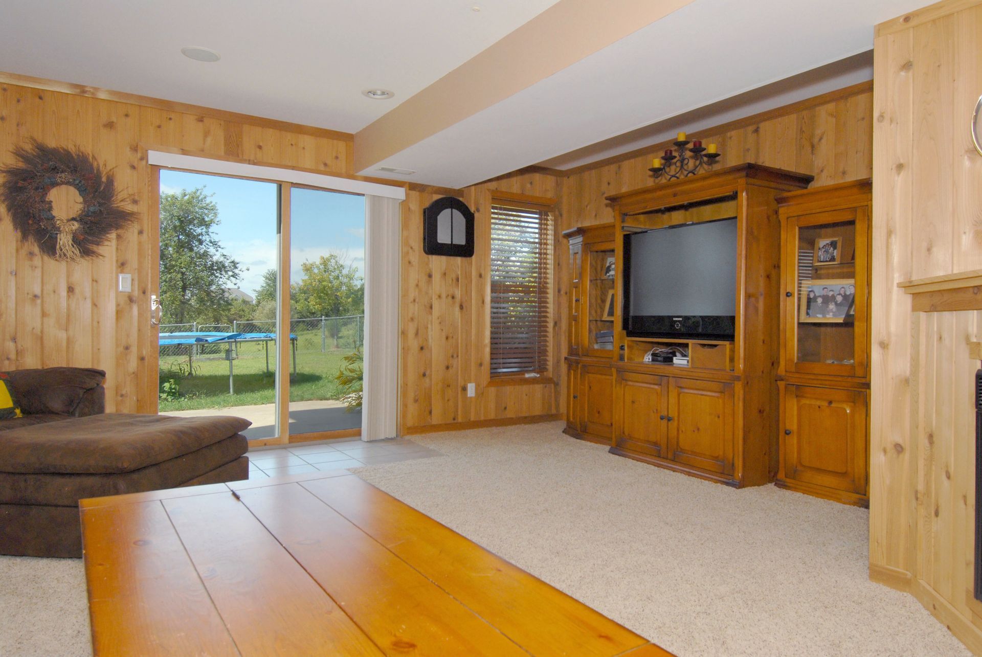 a living room with wood paneling and a flat screen tv
