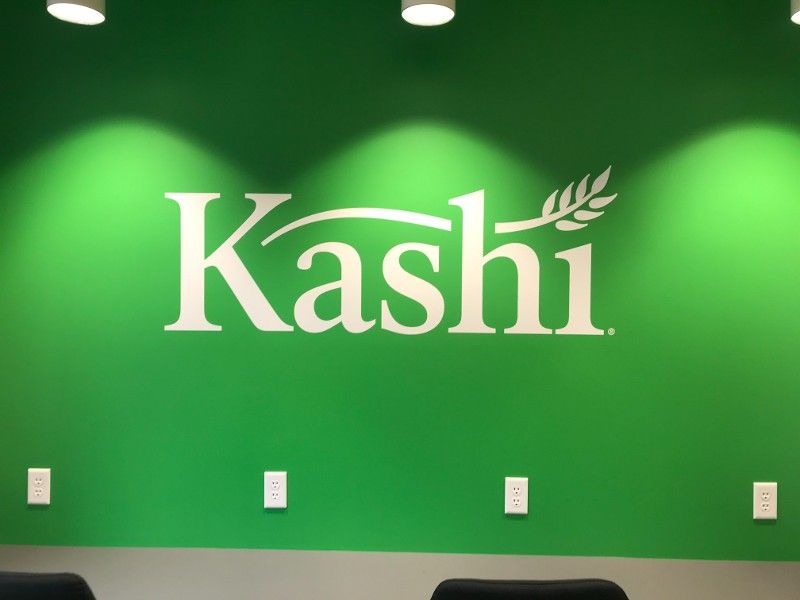 A green wall with a white kashi logo on it