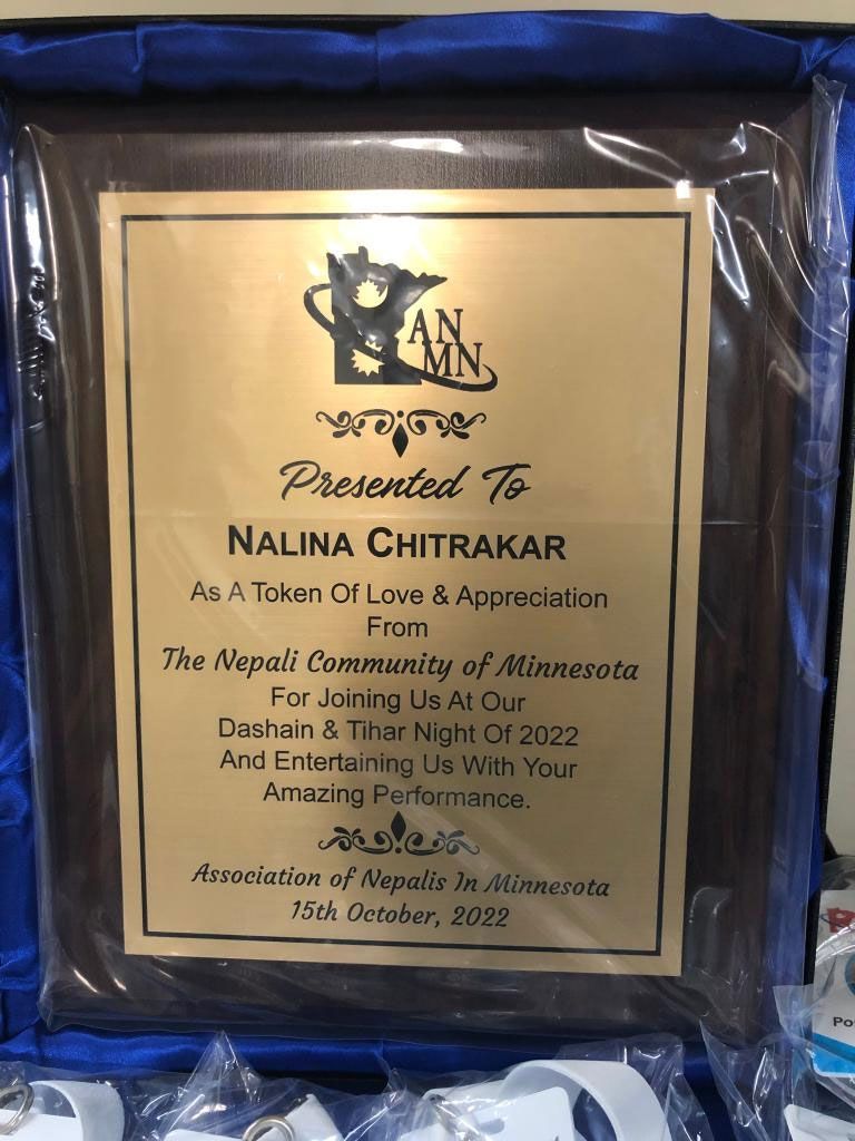 A plaque that says nalina chitrakar on it