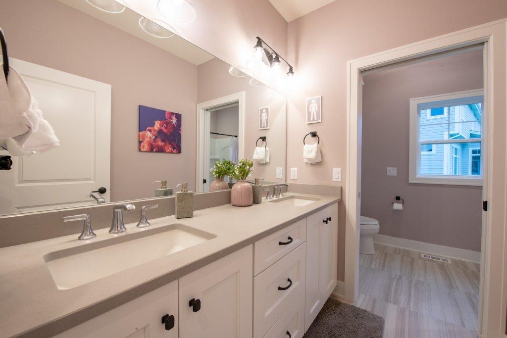 A bathroom with two sinks and a large mirror.