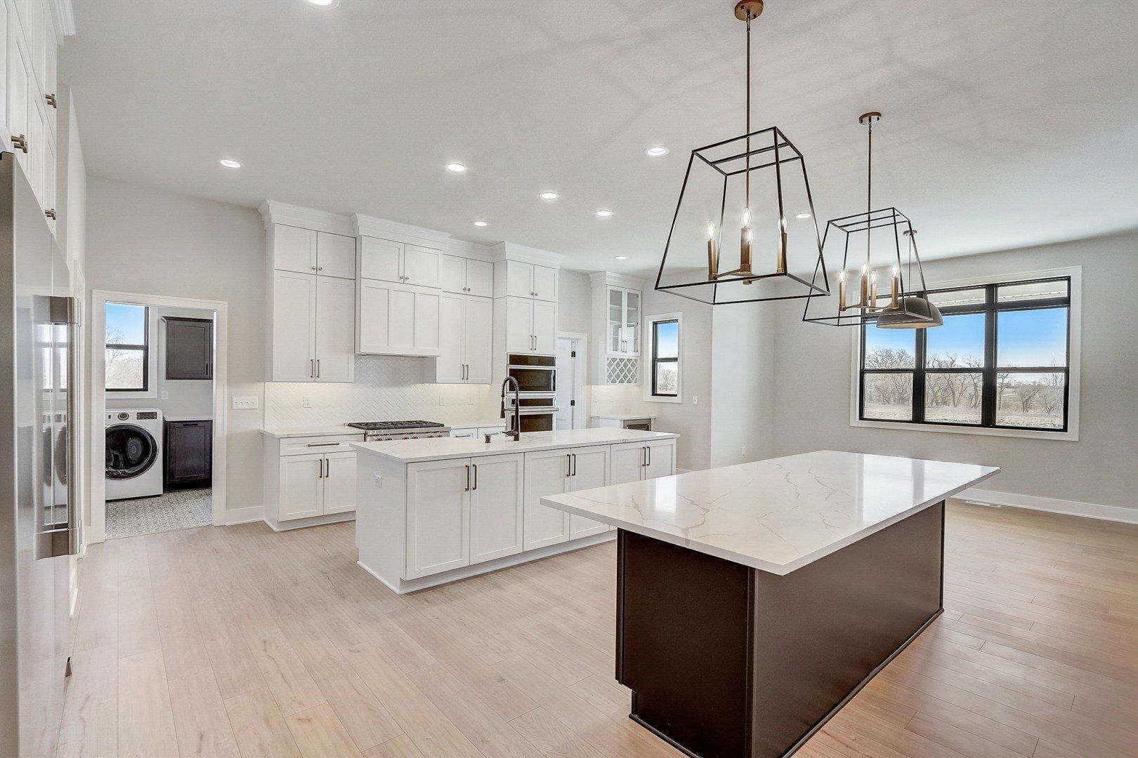 A kitchen with white cabinets and a large island in the middle of the room.