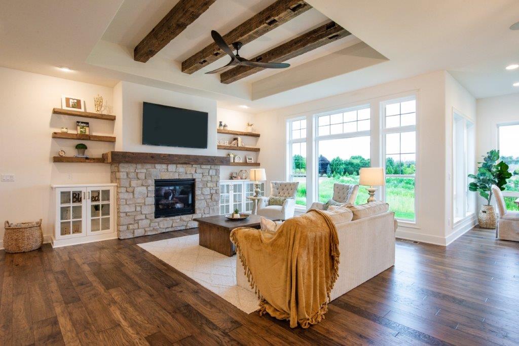 It is a living room with hardwood floors and a fireplace.