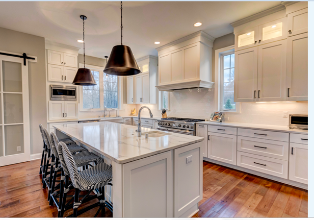 A kitchen with white cabinets and a large island in the middle.
