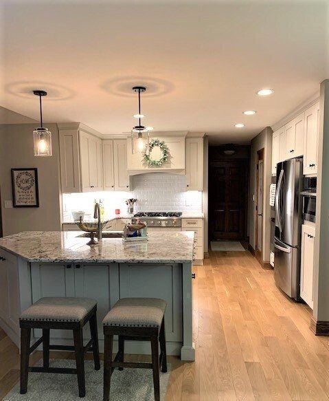A kitchen with stools and a large island in the middle.
