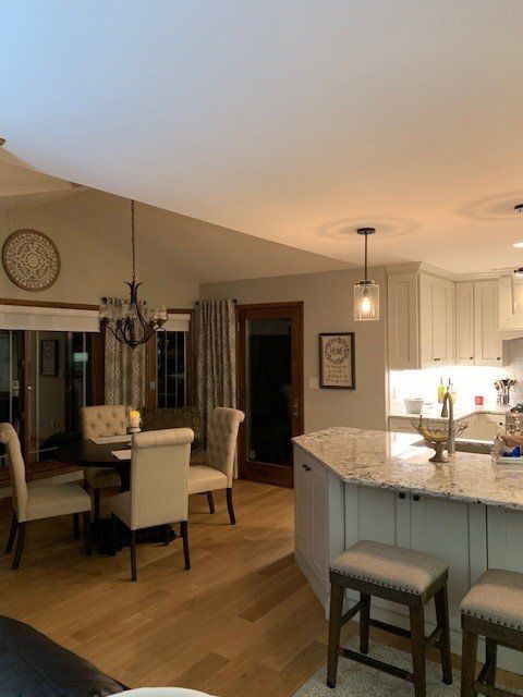 A kitchen with a table and chairs and a clock on the wall