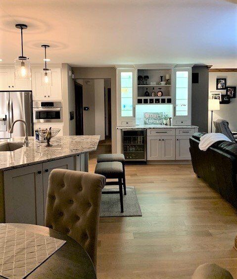A living room filled with furniture and a kitchen with a refrigerator.