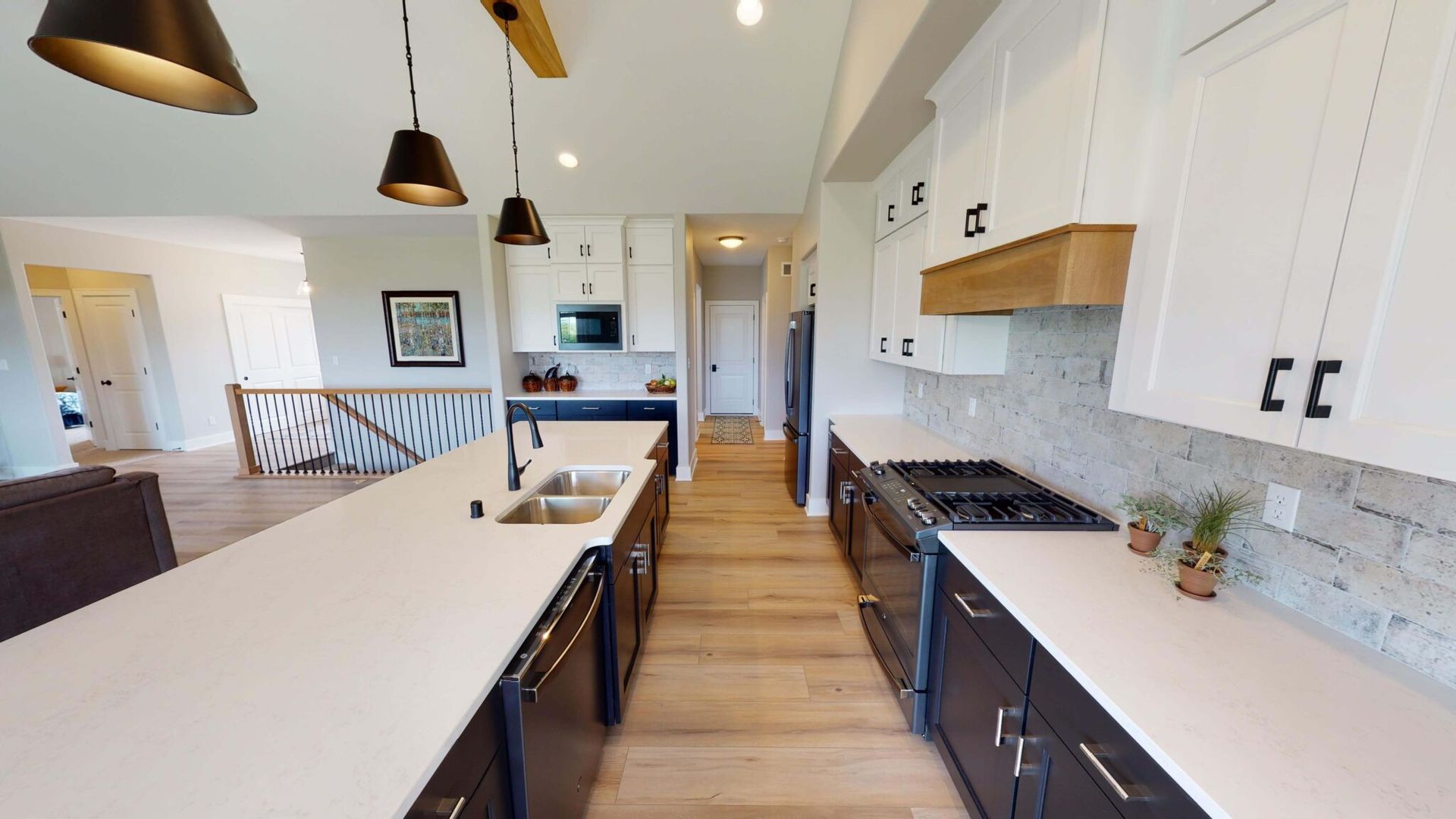 A kitchen in a house with white cabinets and black appliances.