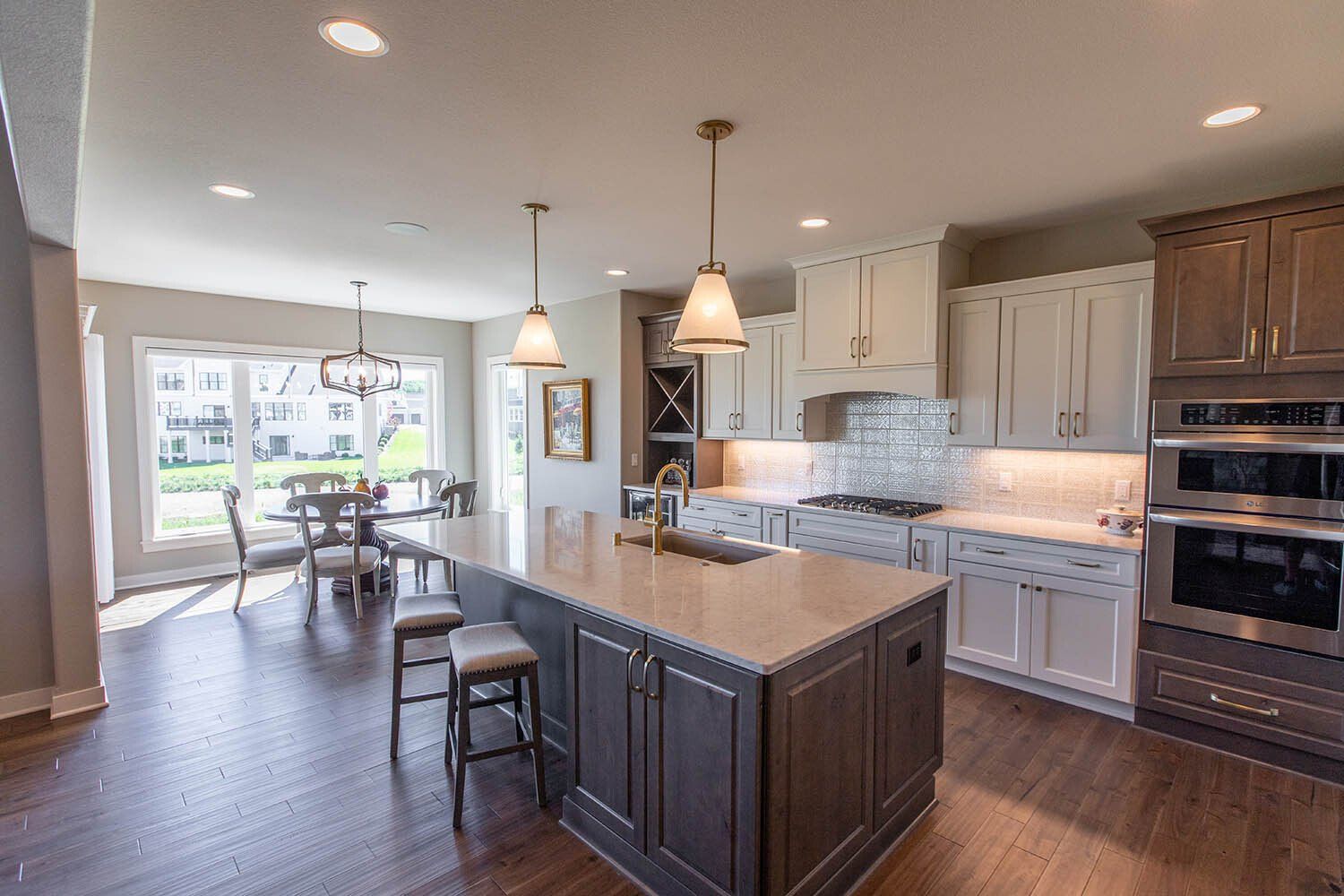 A kitchen with a large island in the middle of it and stainless steel appliances.