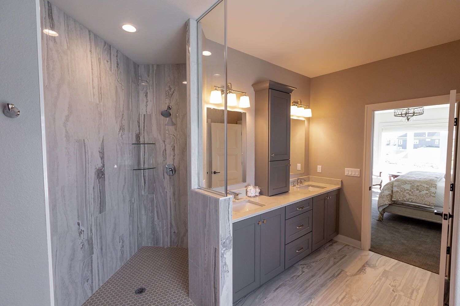 A bathroom with a walk in shower and two sinks.