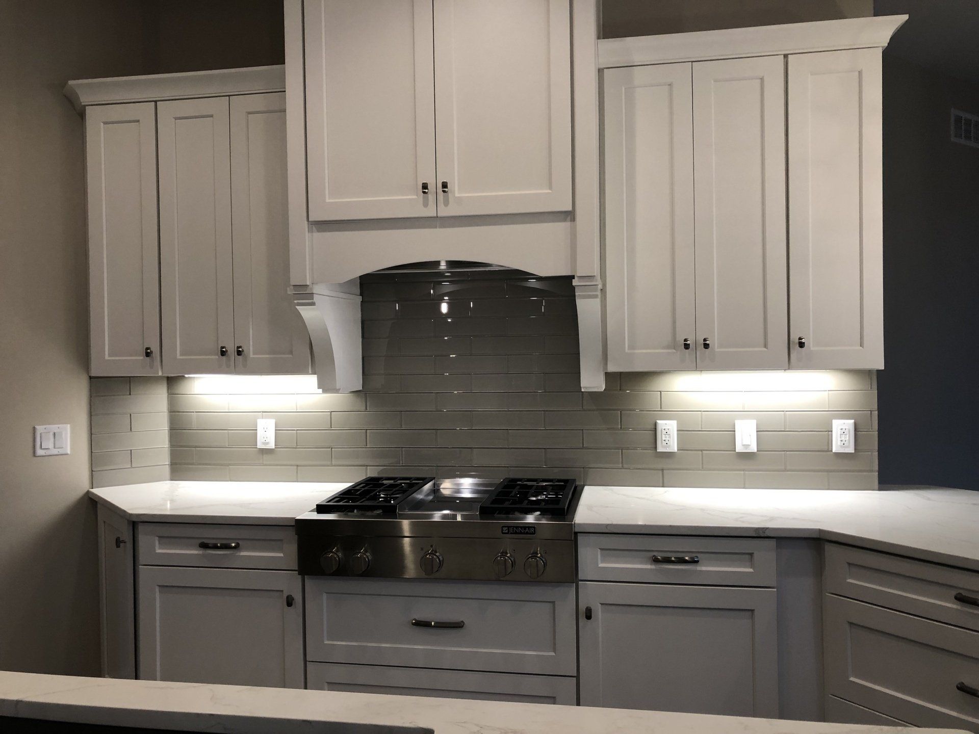 A kitchen with white cabinets and a stove top oven