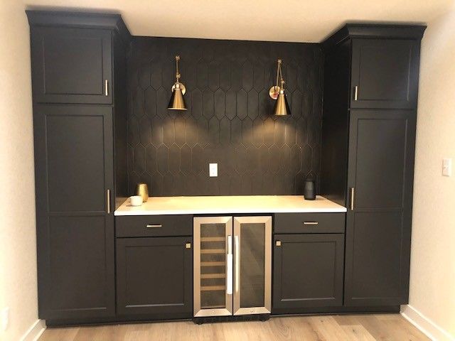 a kitchen with black cabinets and a wine cooler