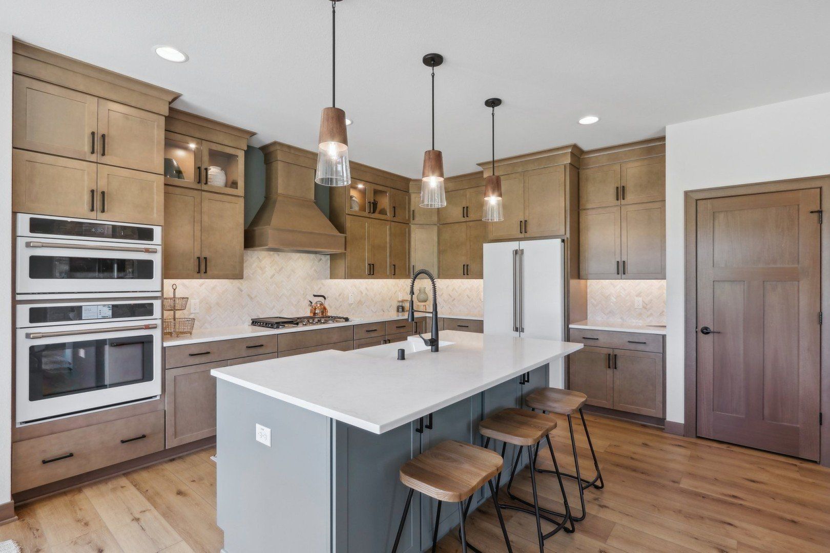 A kitchen with wooden cabinets , stainless steel appliances , and a large island.