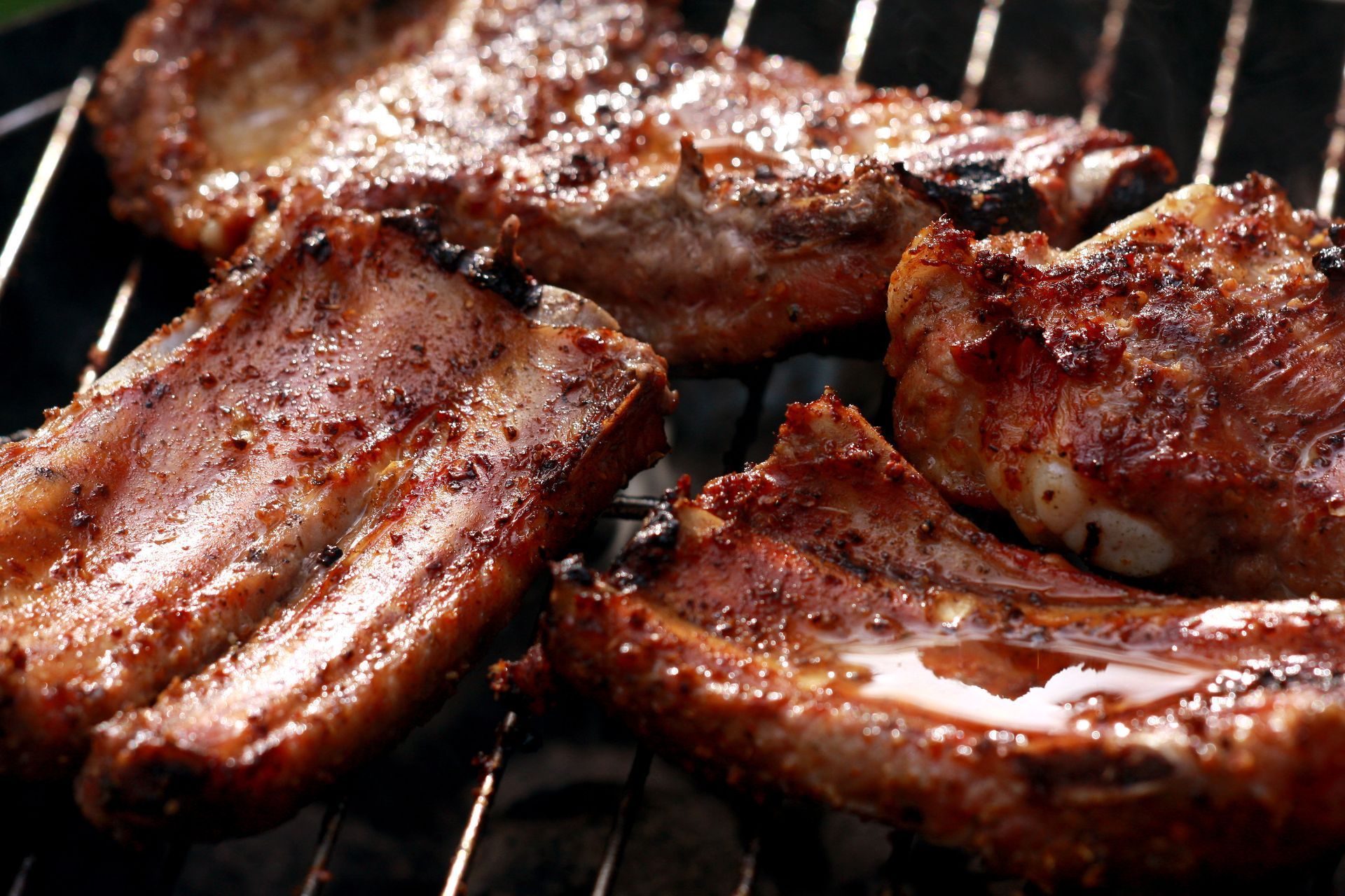 A close up of ribs cooking on a grill