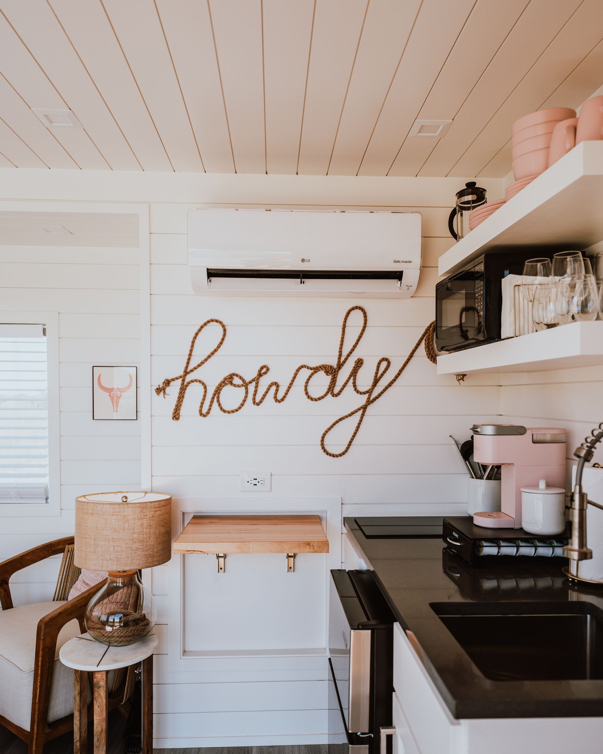 A kitchen with a sign on the wall that says howdy.