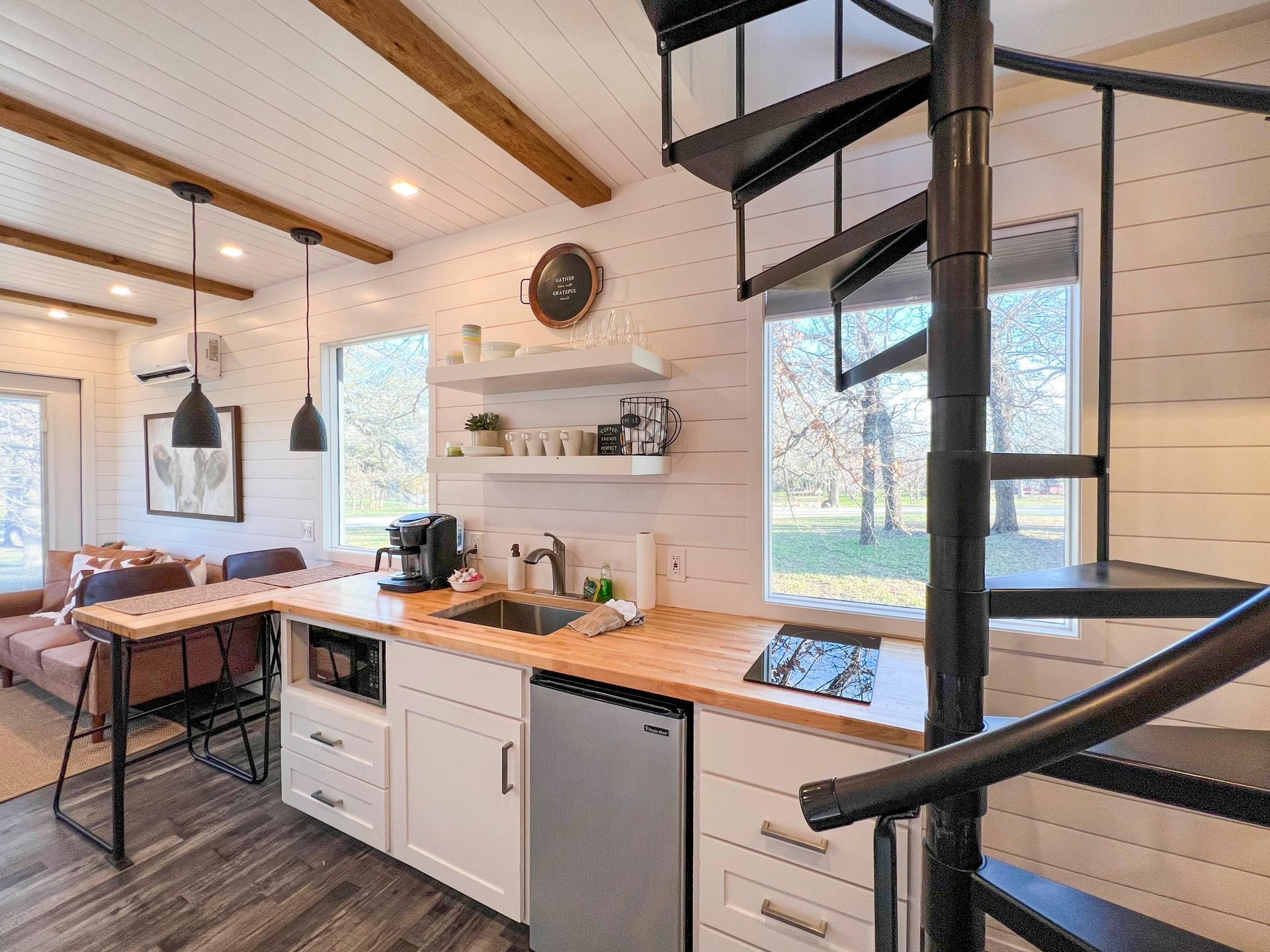 A kitchen with a spiral staircase leading to the second floor.