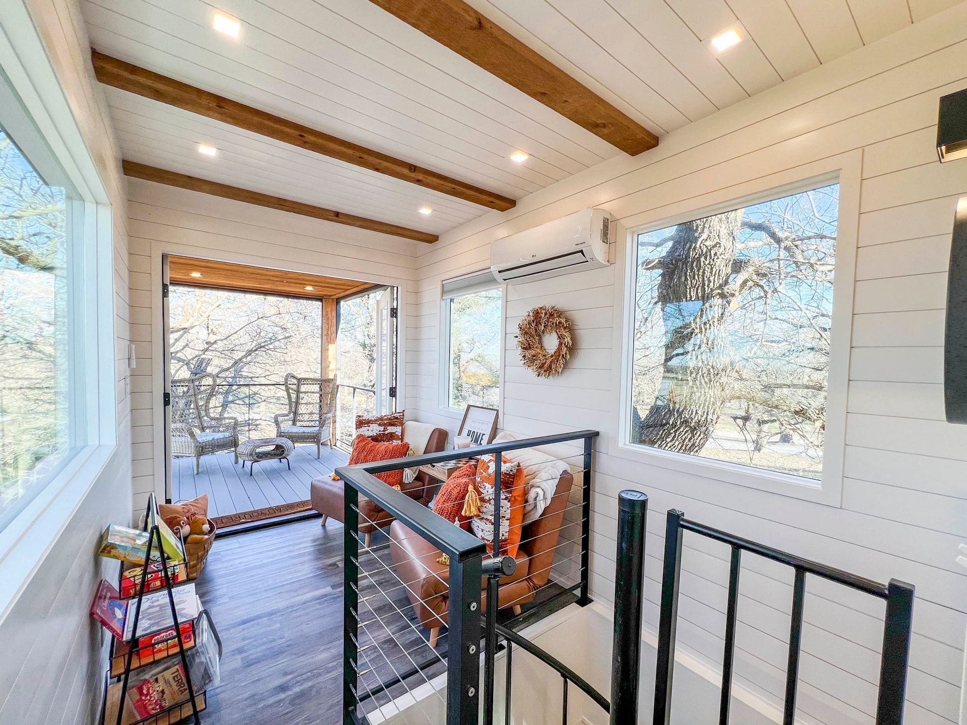 A living room with a couch, chairs, and a balcony.