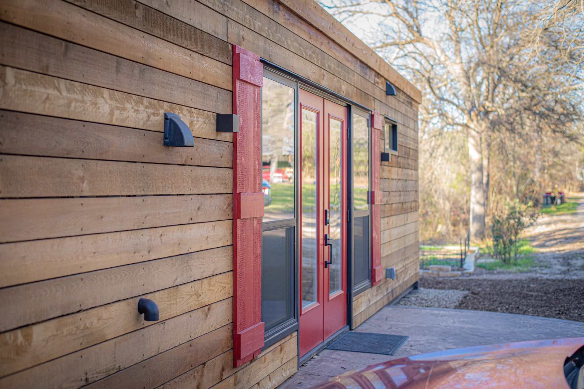A wooden building with red doors and windows.