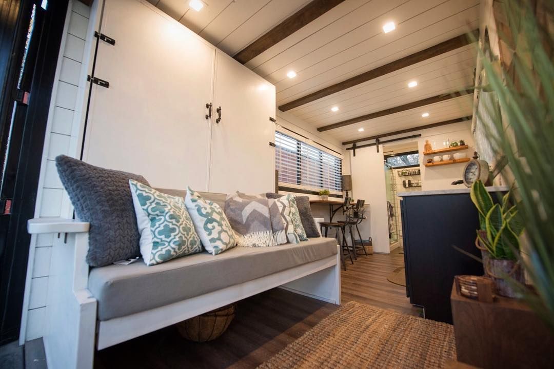 A living room with a couch and pillows in it.