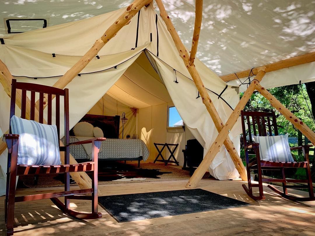 A tent with two rocking chairs in front of it.