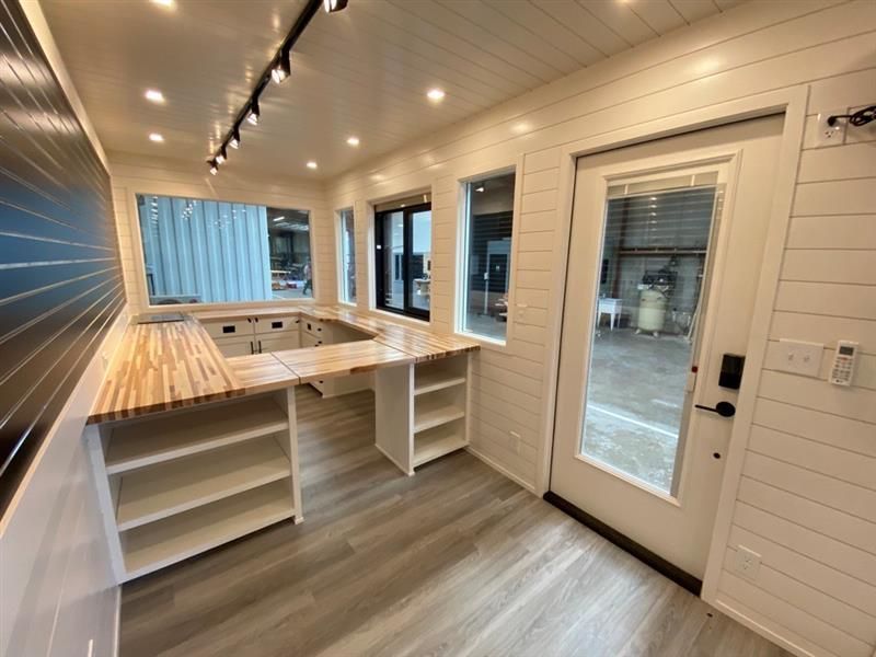 a room with a desk, shelves, and a door