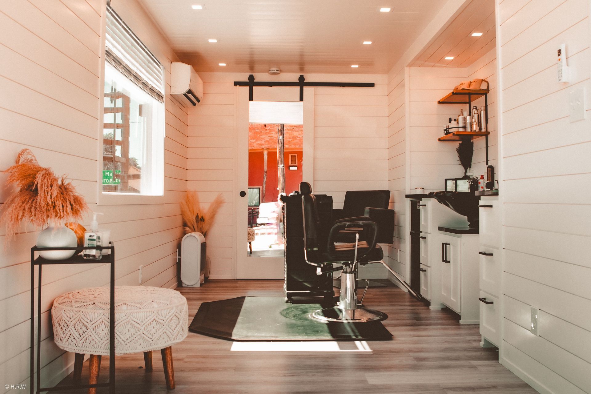a salon with a sliding glass door and a chair in the middle of the room
