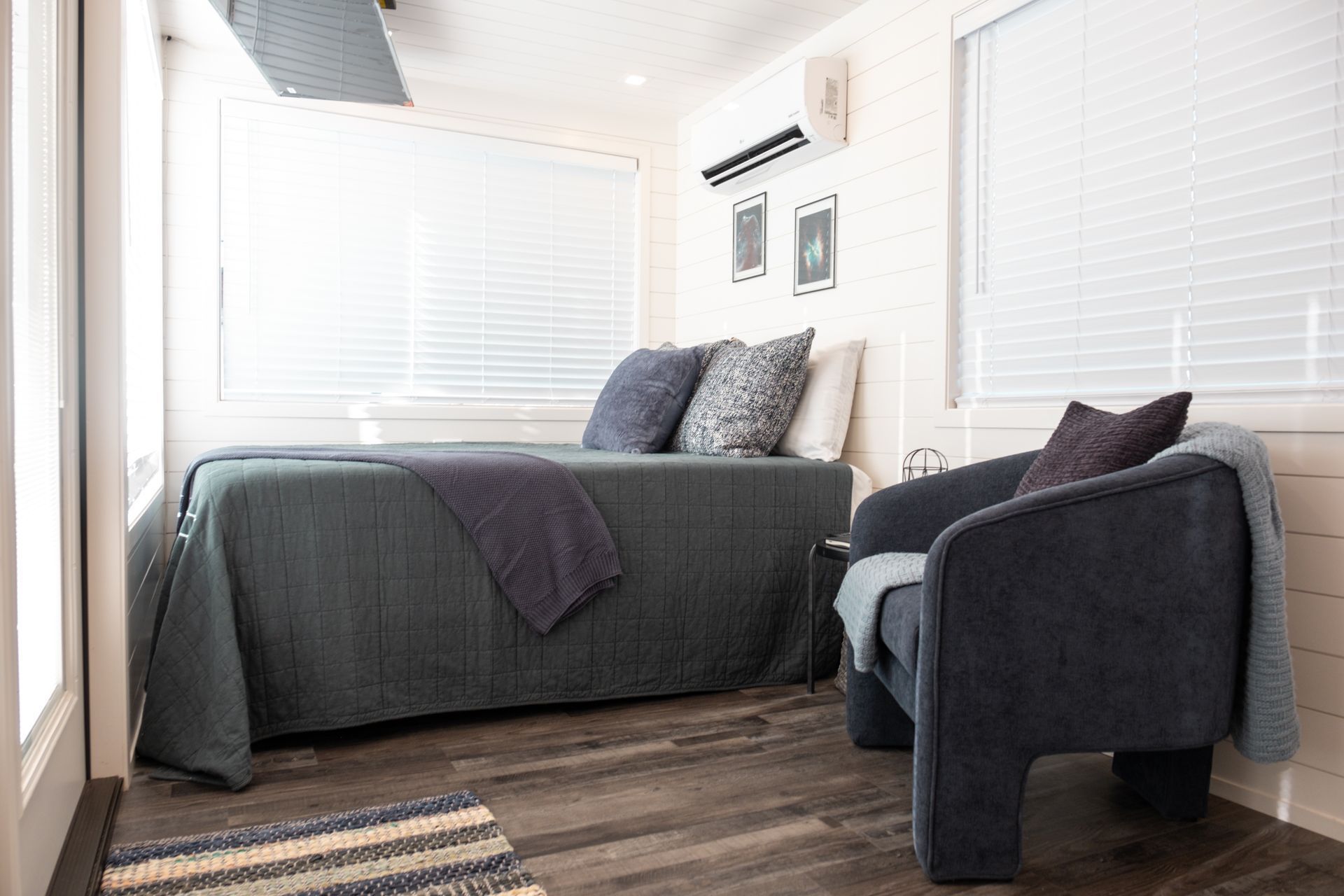 a bedroom with a bed, chair and window