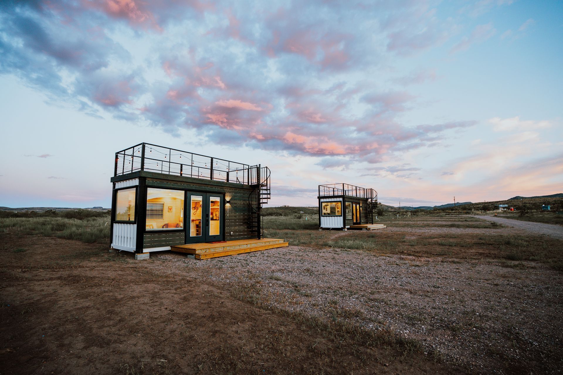 a couple of small houses sitting on top of a dirt field