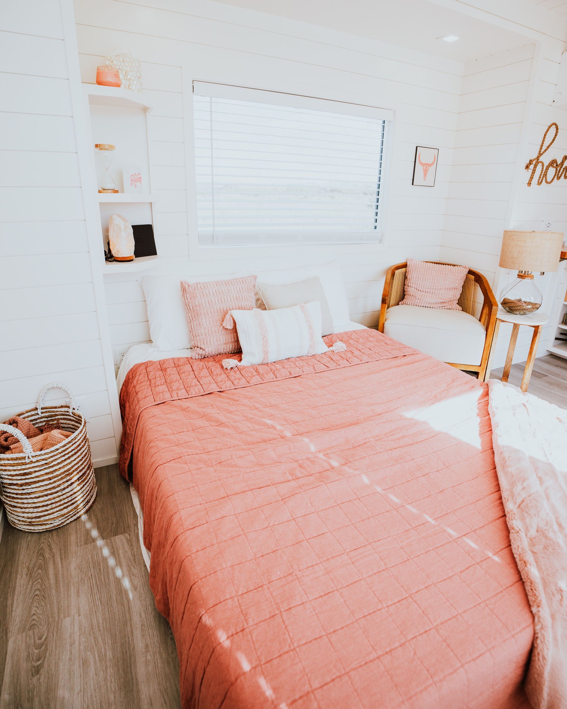 a bedroom with a bed, chair, table and window