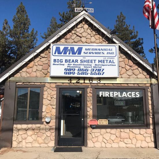 M&M Mechanical Services and Big Bear Sheet Metal storefront with a stone facade, a glass door, and large front windows.