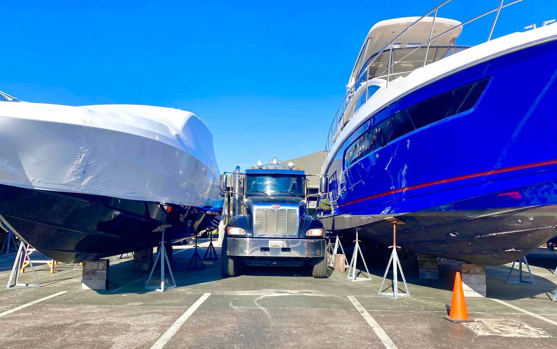 Two boats are sitting next to each other in a parking lot