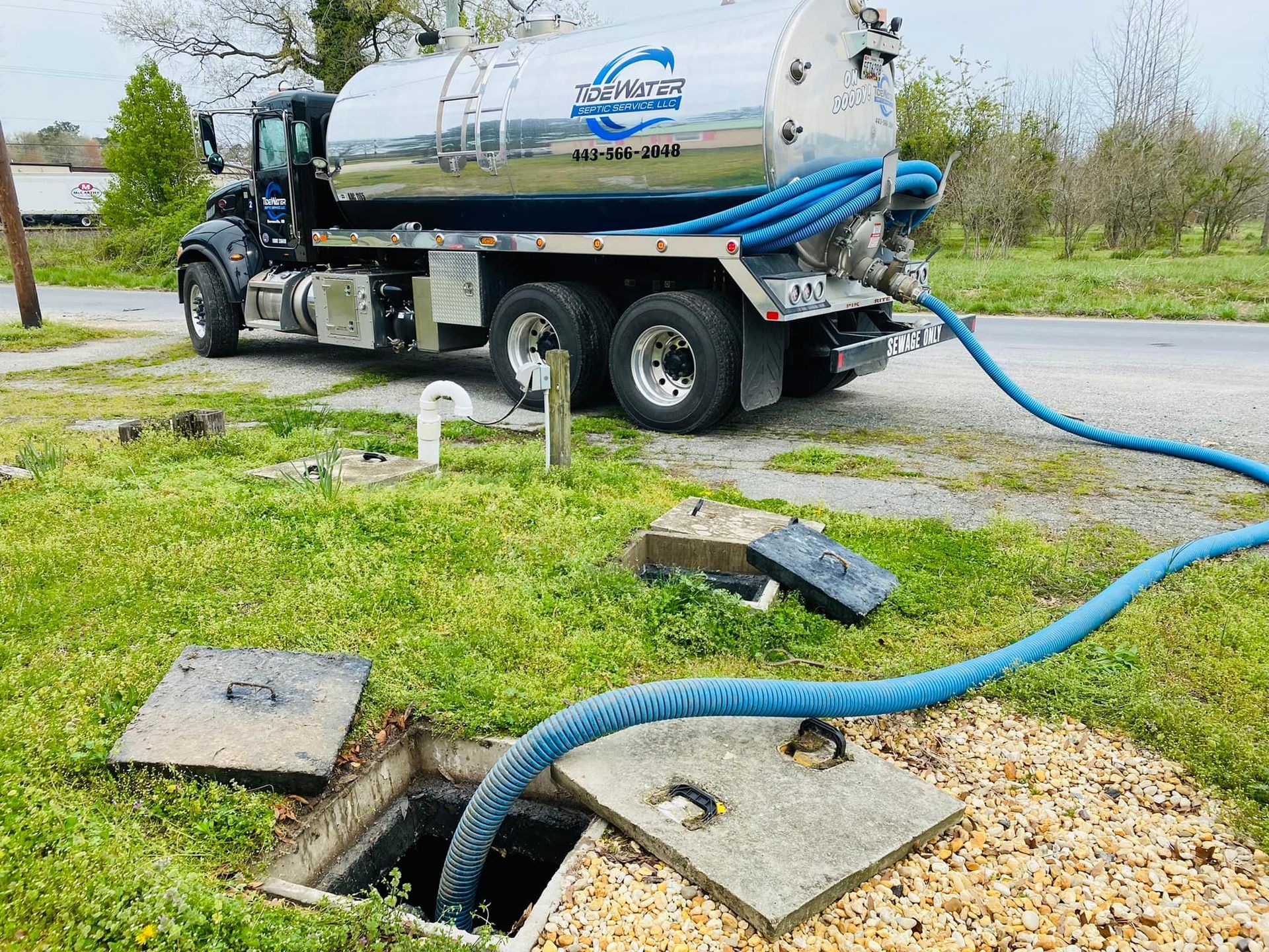 A septic tank truck is pumping water into a septic tank