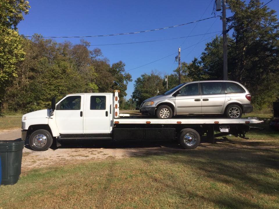 A tow truck with a minivan on the back of it.
