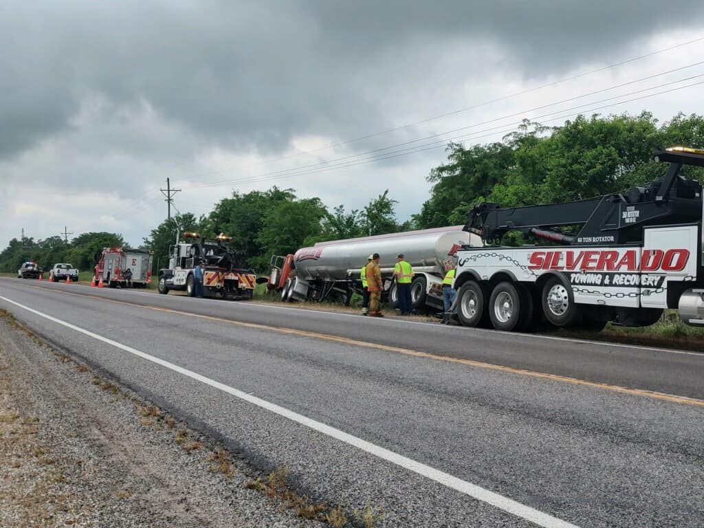 A silverado tow truck is parked on the side of the road.