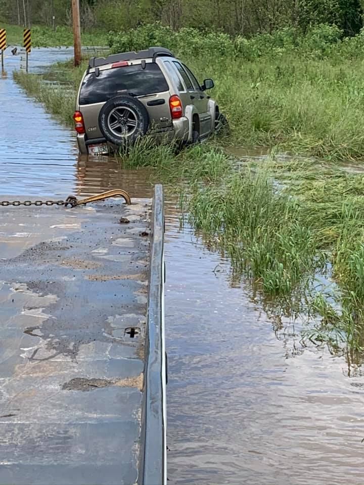 A car is stuck in a flooded road.