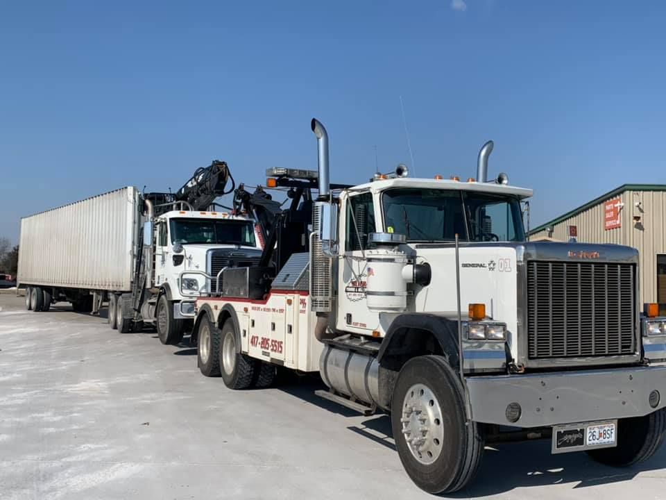 Two tow trucks are parked next to each other in a parking lot.