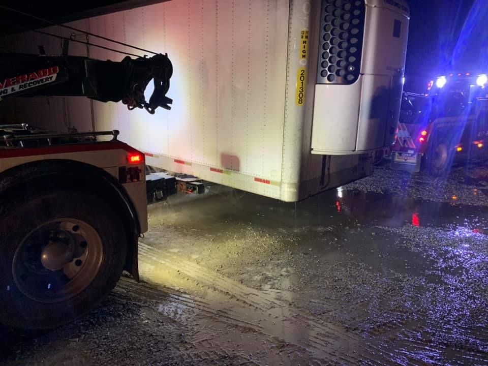 A truck is being towed by a tow truck in the snow.