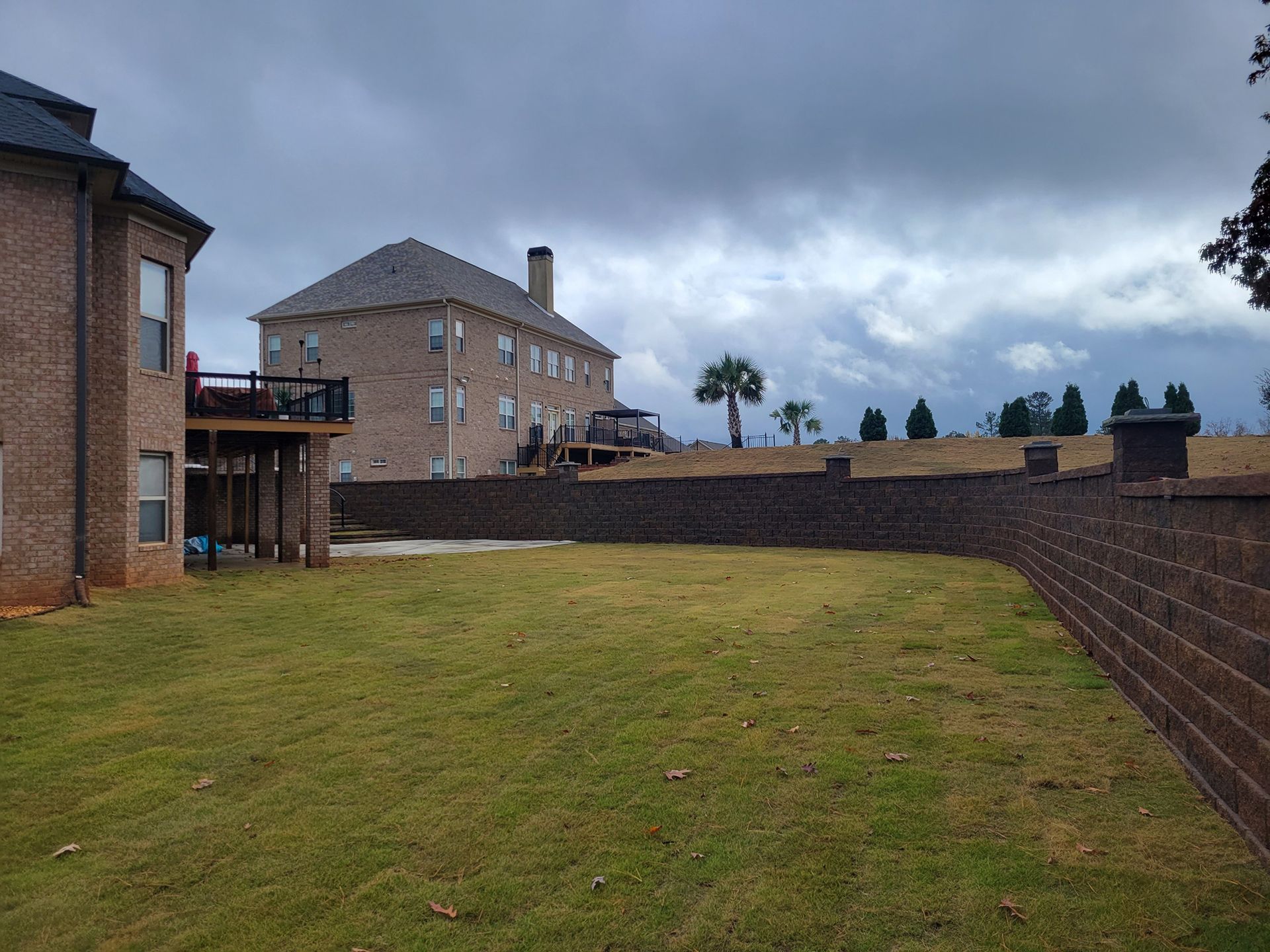 A large brick house with a large lawn in front of it