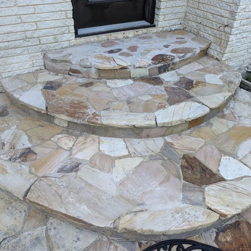 A stone porch with steps leading up to a door.