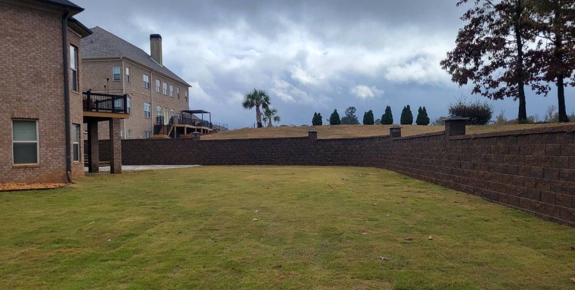 A large brick house with a large lawn in front of it.