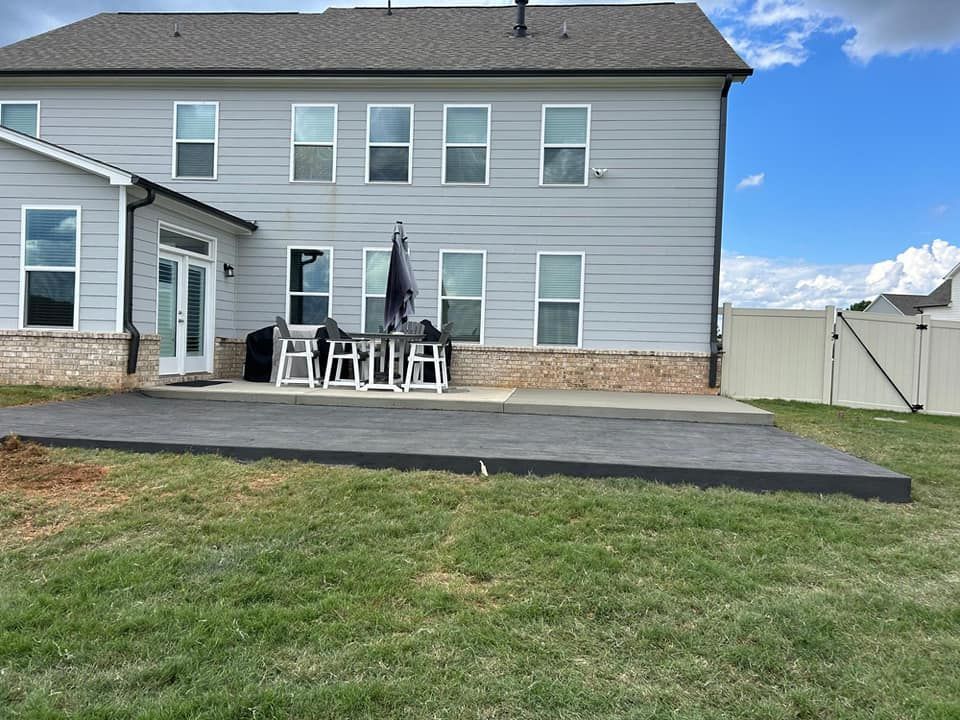 The backyard of a house with a patio and a table, and chairs.