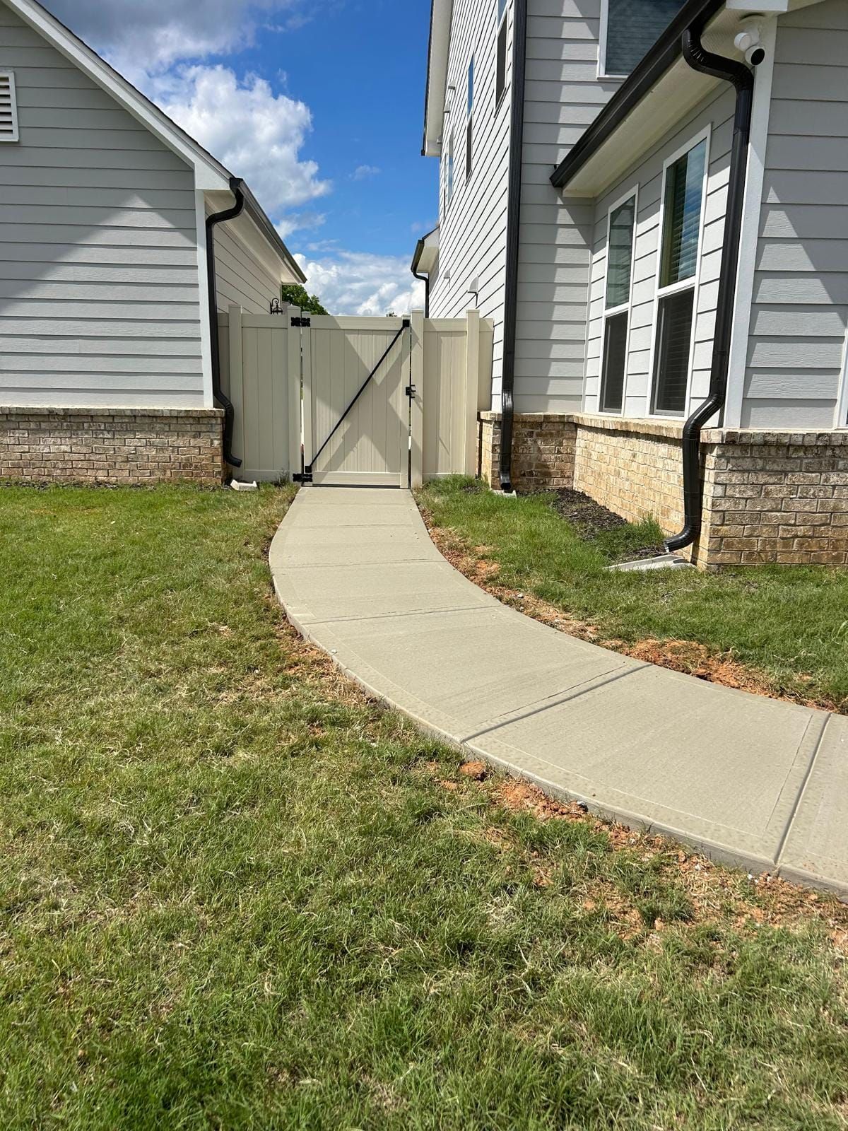 There is a concrete walkway between two houses.
